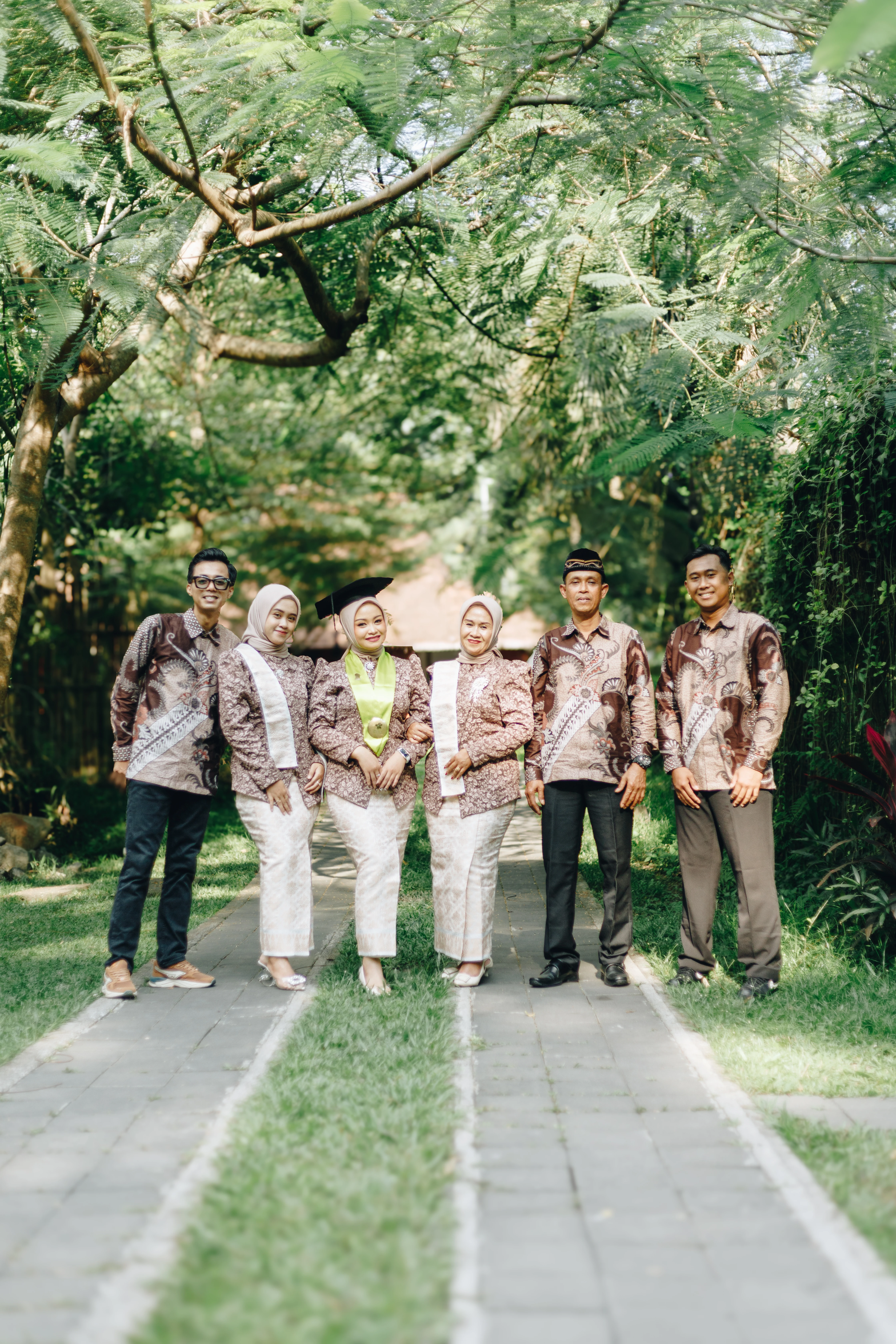Foto wisuda personal mahasiswa berlatar arsitektur modern kampus UMY Yogyakarta dengan pewarnaan hangat dan jernih - Toga & Co.
